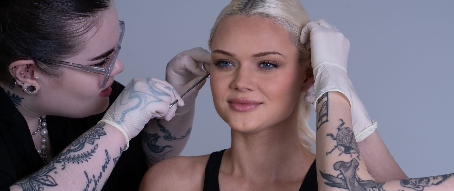 Two SkinKandy piercers with a model during a piercing